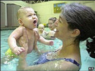 An eight-month-old resurfaces in his mother's arms in a US baby swimming class